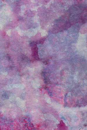 An abstract watercolor painting blending various shades of lilac and lavender on a white canvas.