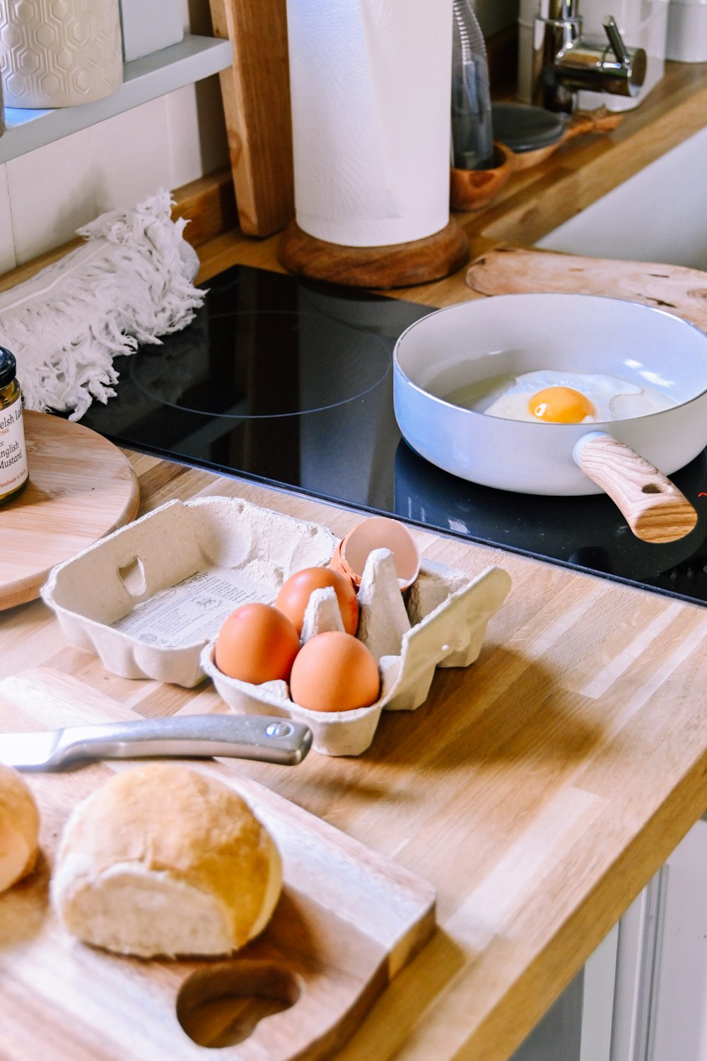 una tabla de cortar de madera cubierta con huevos junto a un tazón de huevos