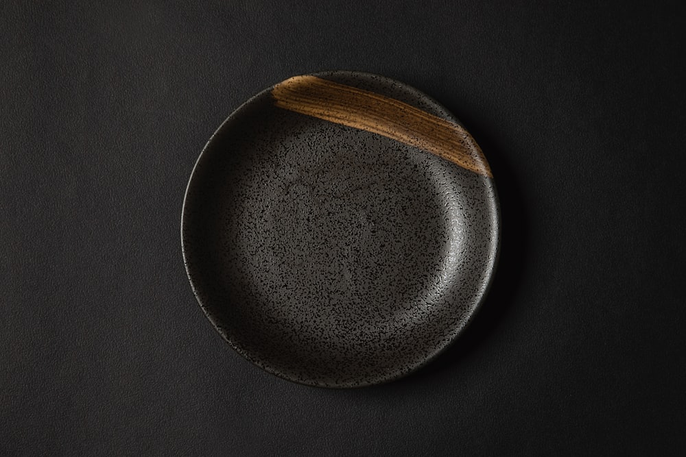 a black plate with a wooden spoon on it