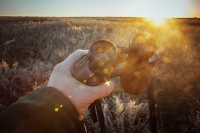 a person holding a camera in a field