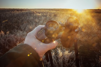 a person holding a camera in a field