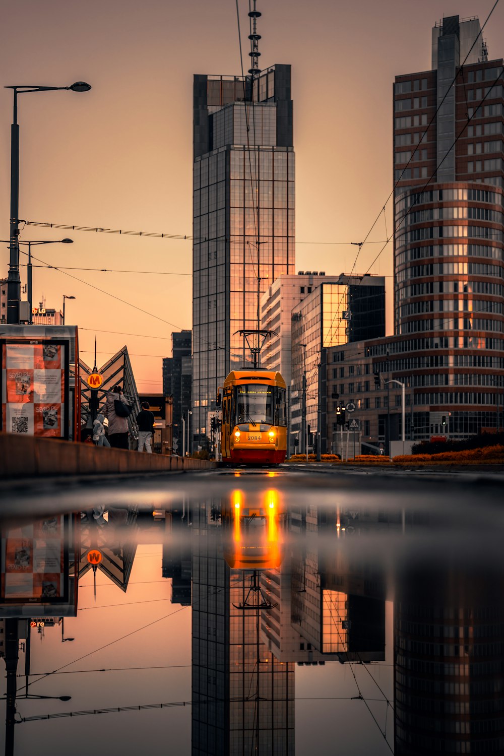 a yellow train traveling through a city next to tall buildings