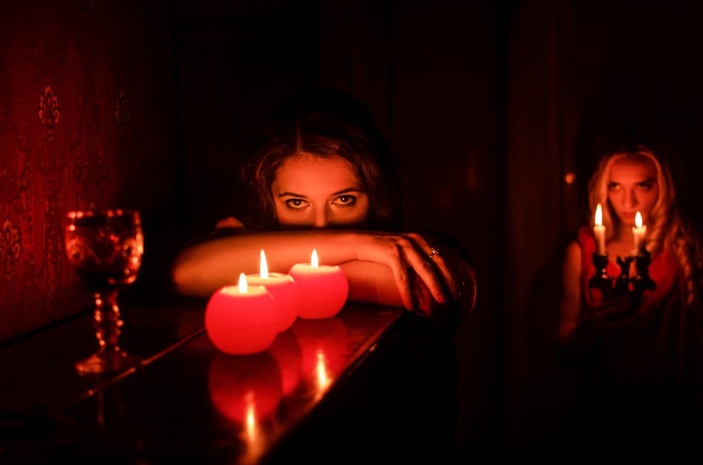 a woman sitting at a table with candles in front of her