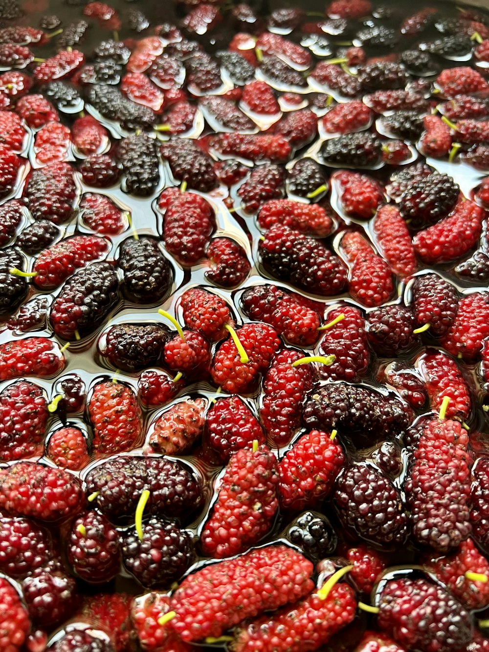 raspberries and blackberries are being cooked in a pan