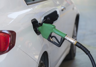 a white car with a green gas pump