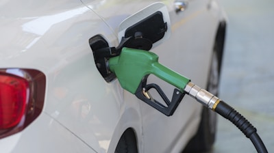 a white car with a green gas pump