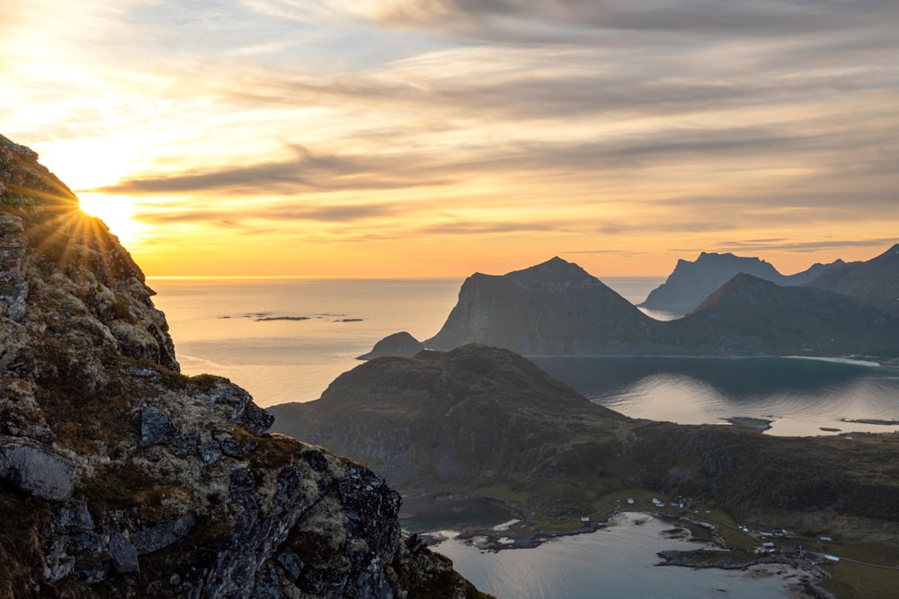 Ein Vogel sitzt auf einem Felsen mit Blick auf einen See und Berge