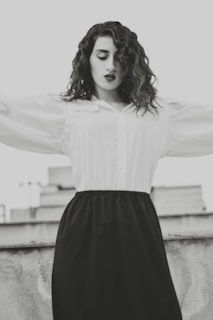 An outdoor shot of a flowing white blouse paired with tailored trousers, catching the breeze.