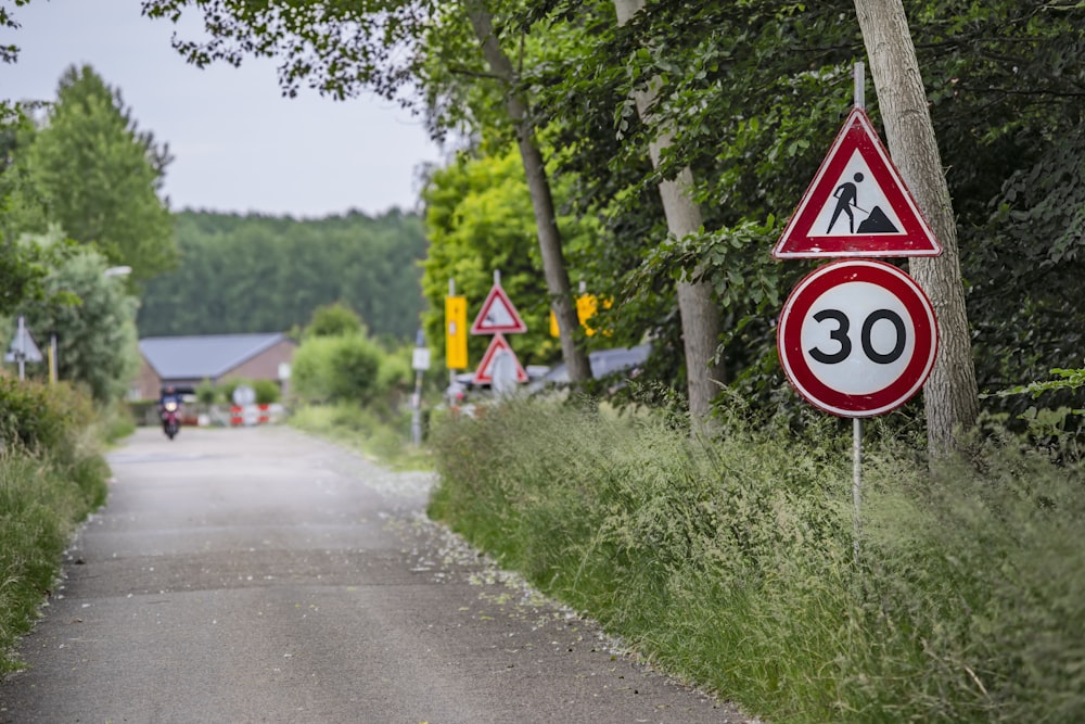 a red and white sign sitting on the side of a road