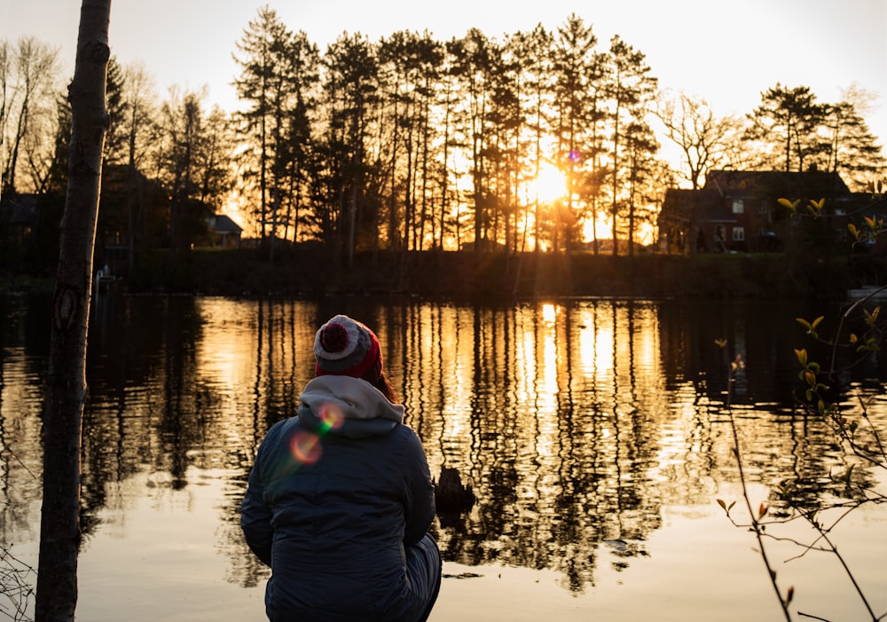 a person sitting in front of a body of water