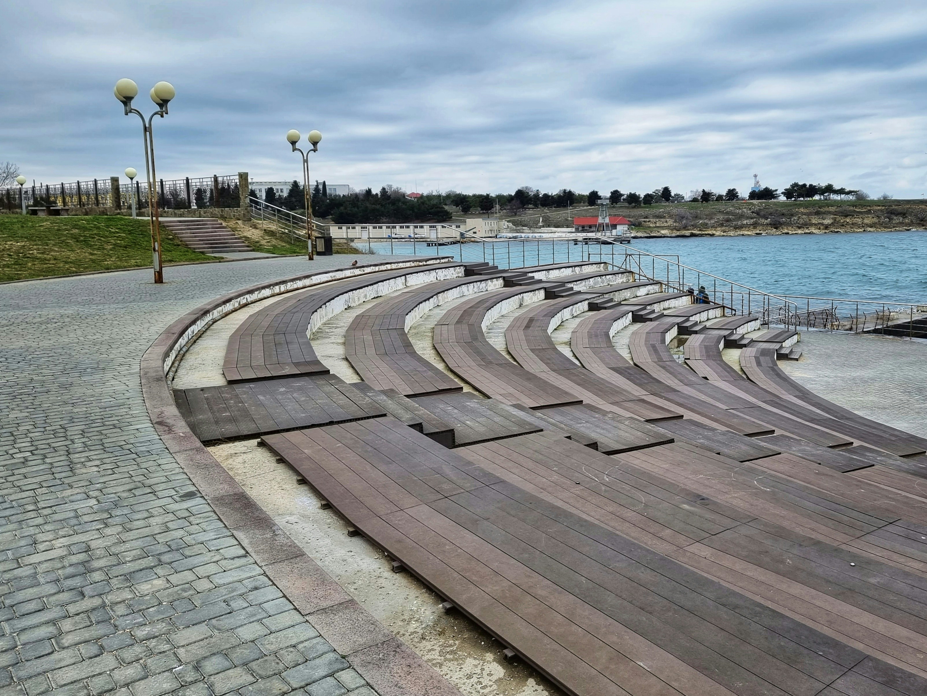 a row of empty seats sitting next to a body of water