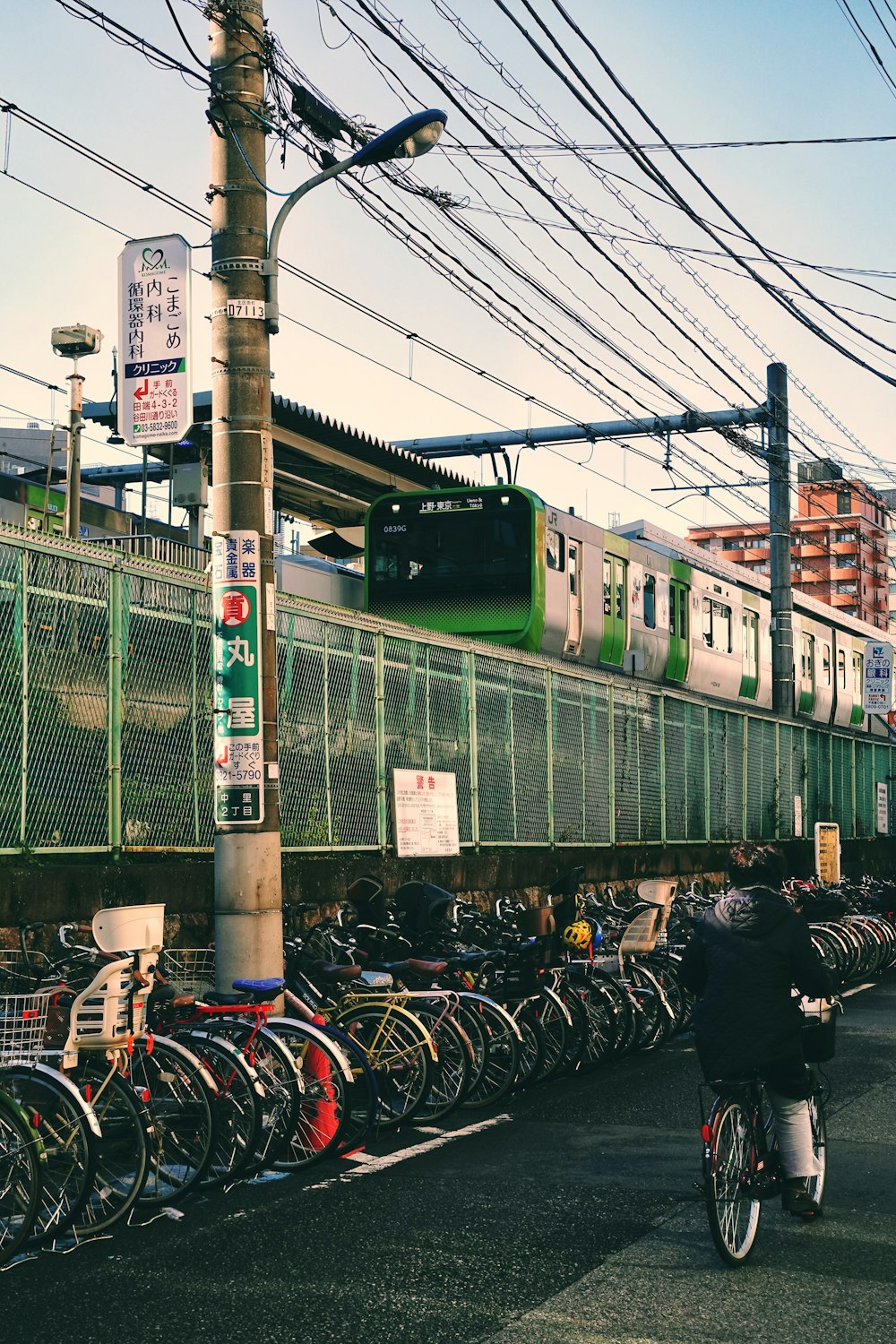 a man riding a bike down a street next to a train