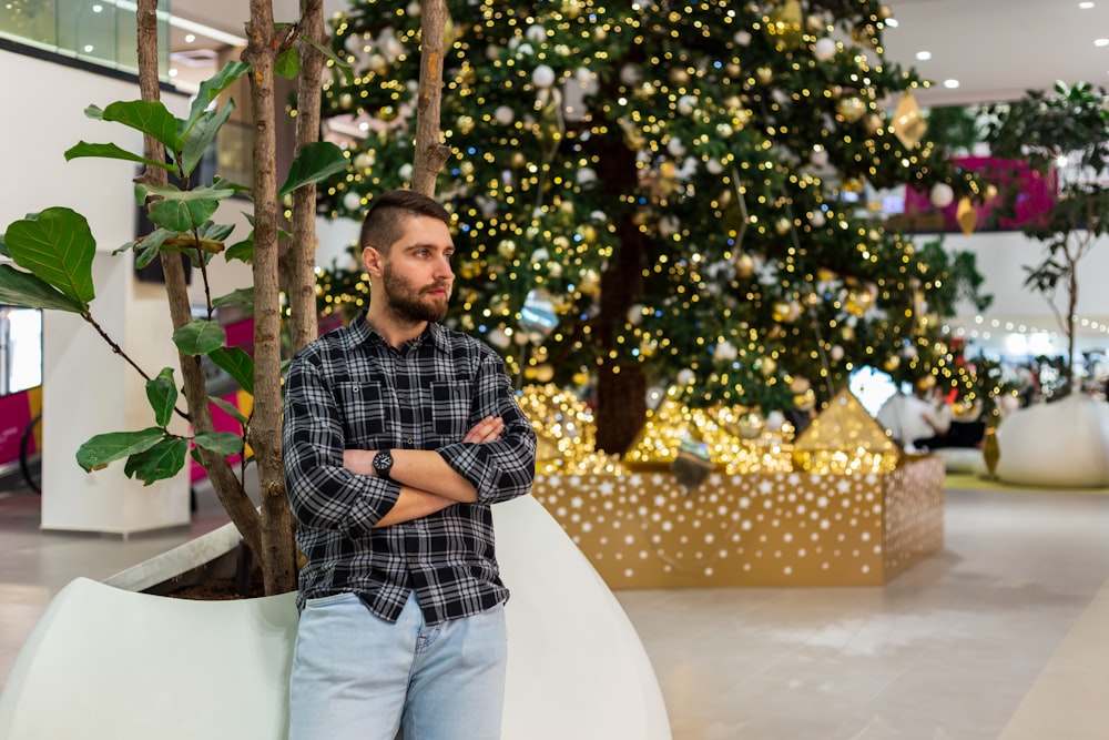 a man standing in front of a christmas tree