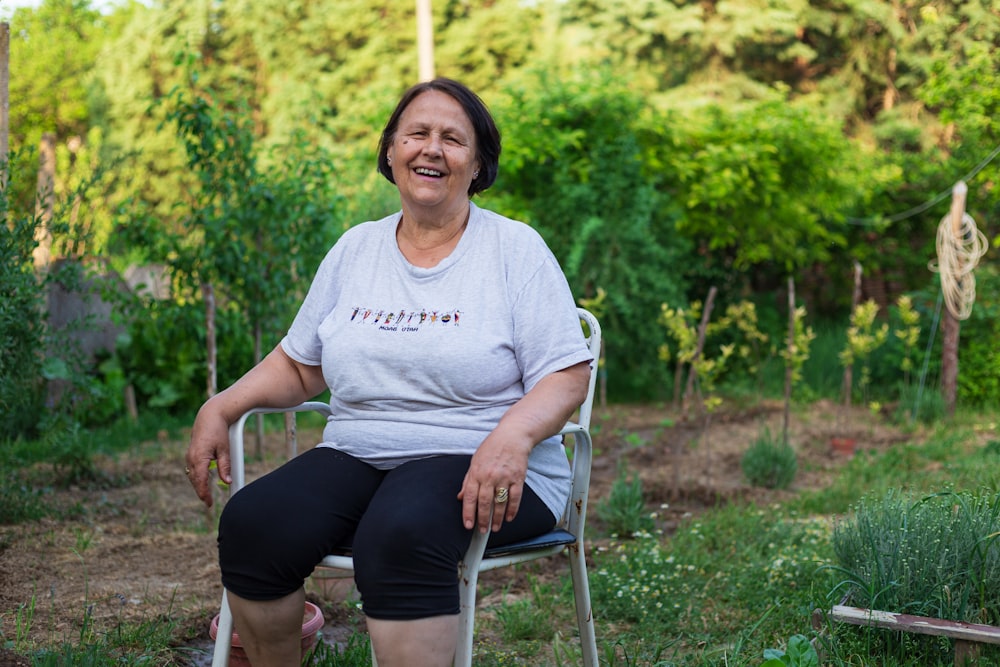 a woman sitting in a chair in a garden