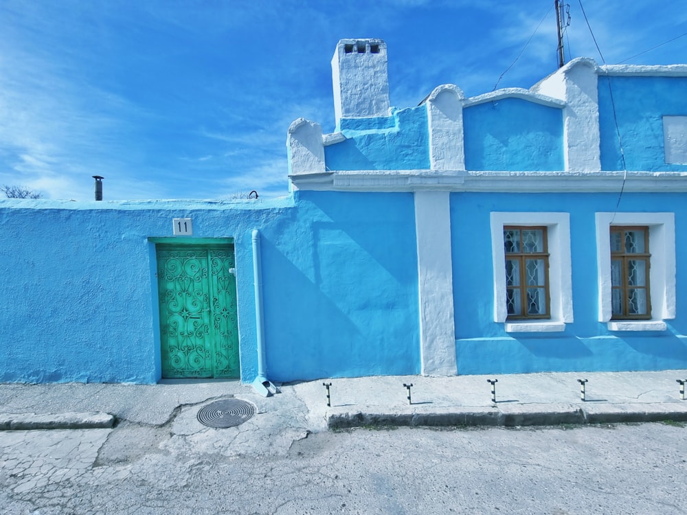 a blue building with a green door and window