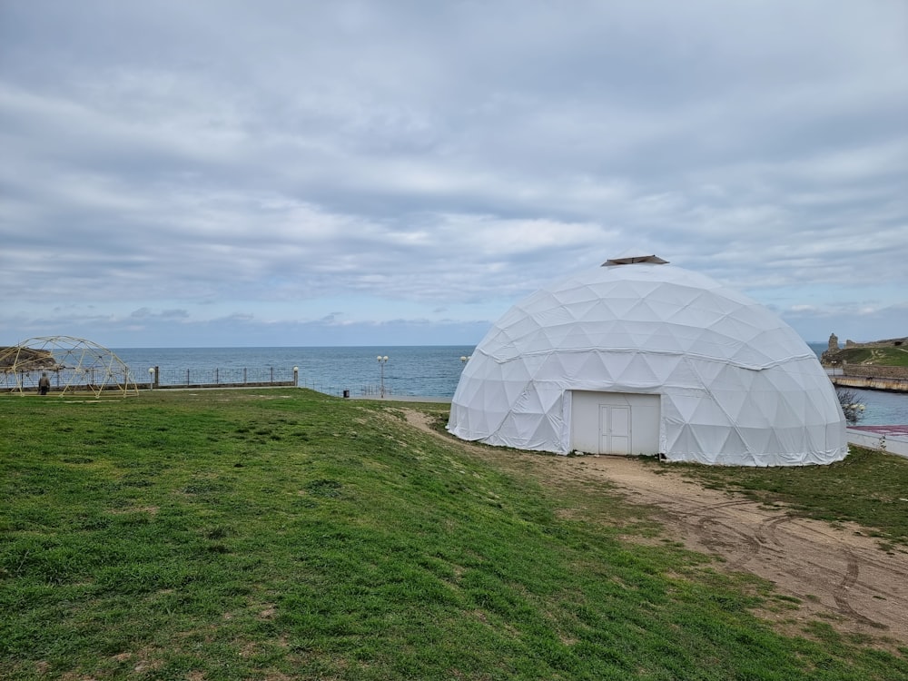 a large white dome sitting on top of a lush green field