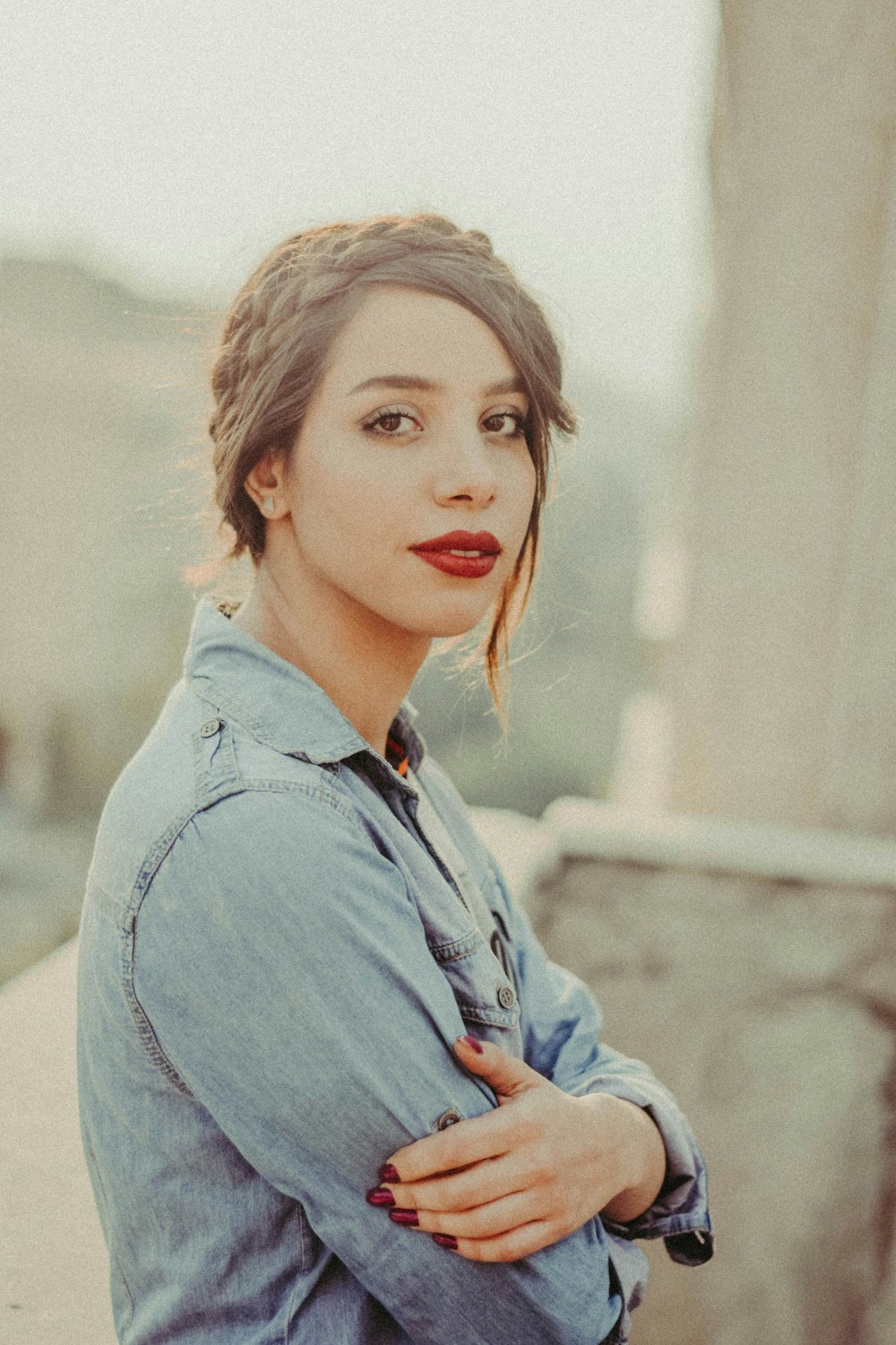 a woman with her arms crossed posing for a picture