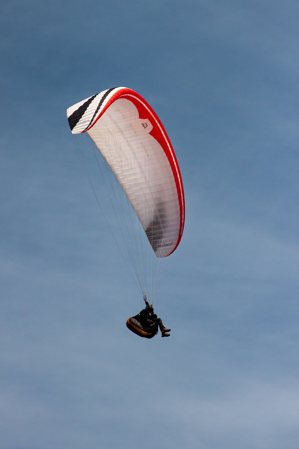 a person is parasailing in the blue sky