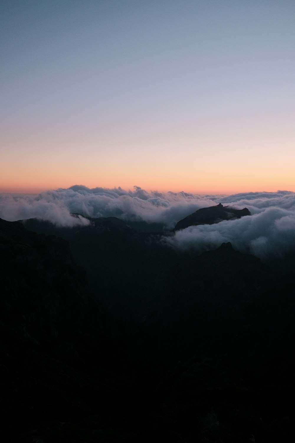 a view of a mountain range with low lying clouds