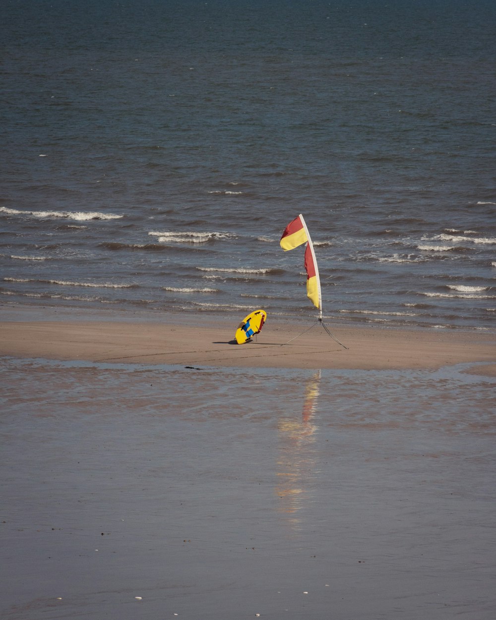 a couple of kites sitting on top of a sandy beach