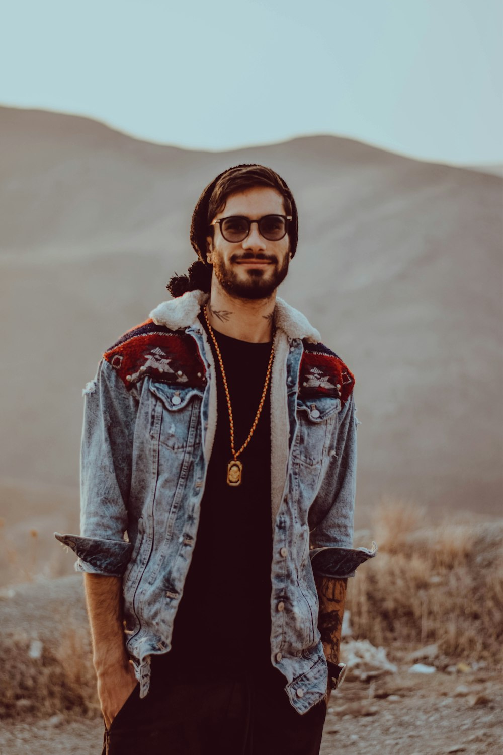 a man wearing a denim jacket and sunglasses