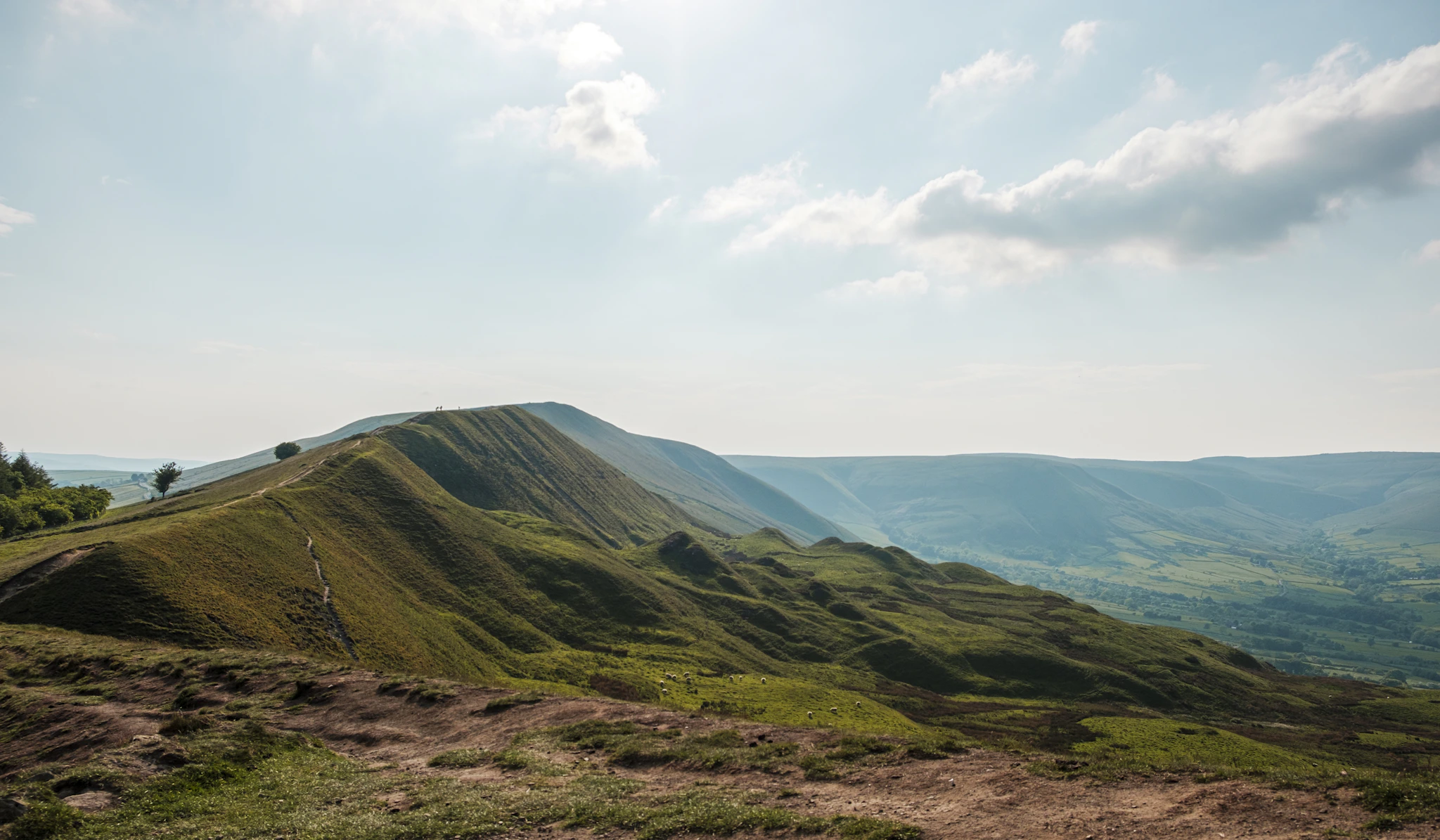 The grassy ridge of Mam Tor above the Hope Valley, one of the best hikes in the Peak District