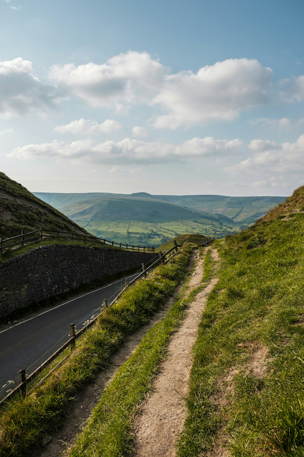 a road going up a hill with a fence on the side