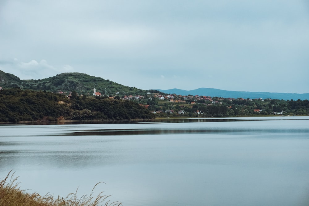 a large body of water surrounded by a lush green hillside