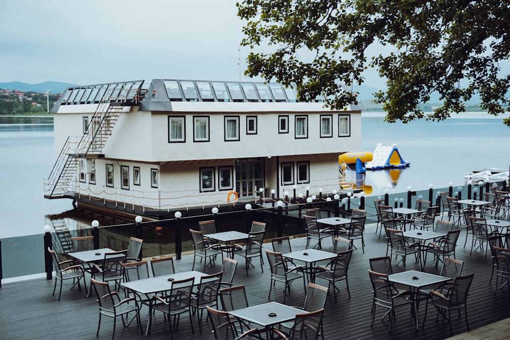 a restaurant with tables and chairs next to a body of water