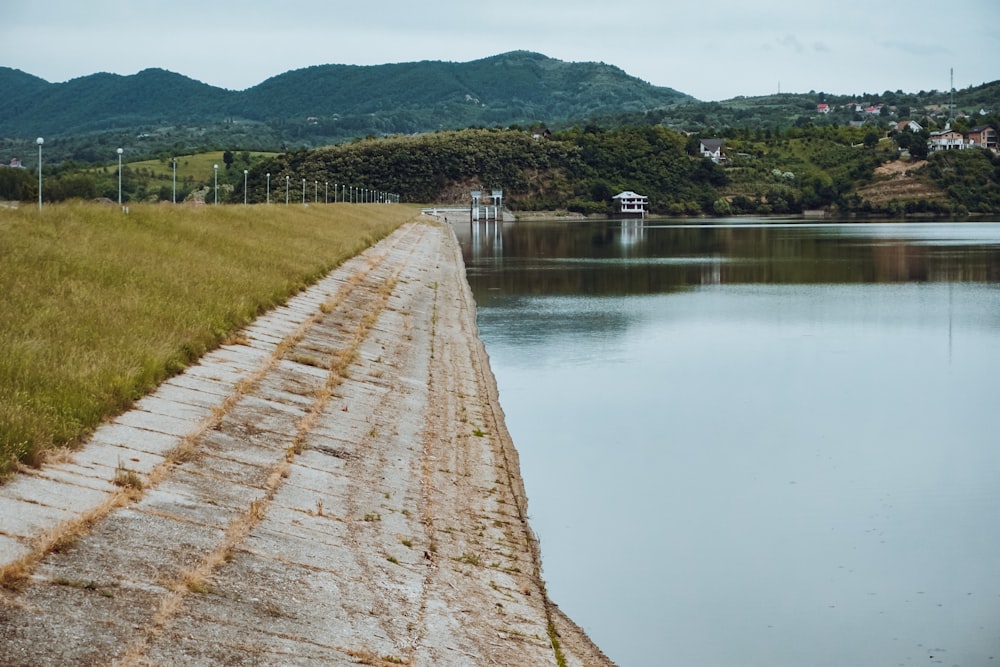 a large body of water sitting next to a lush green hillside