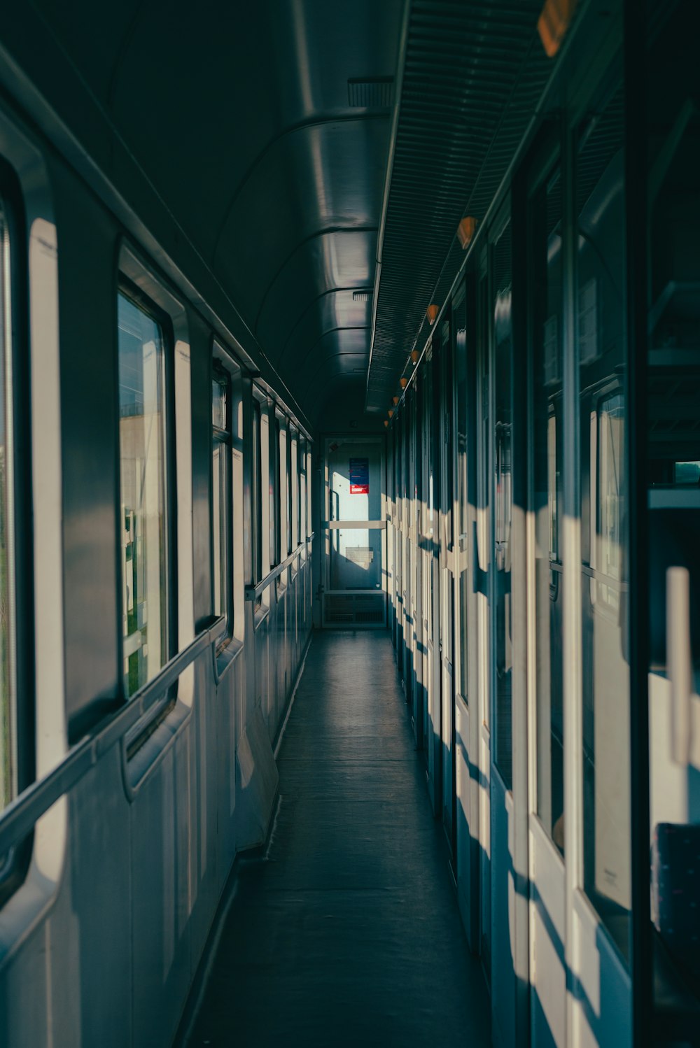 a long narrow hallway with windows and a door