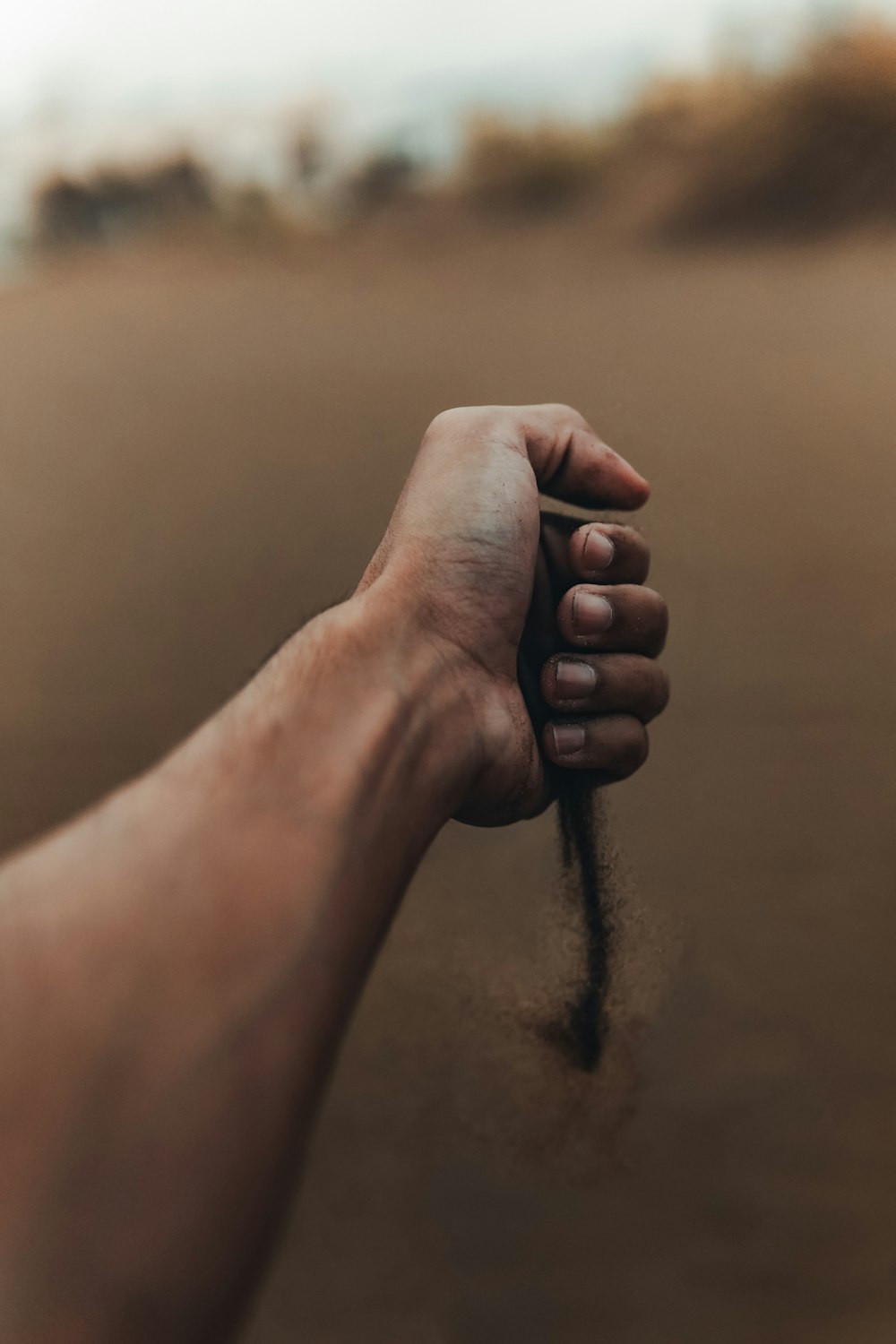 una mano sosteniendo una cuerda en la arena
