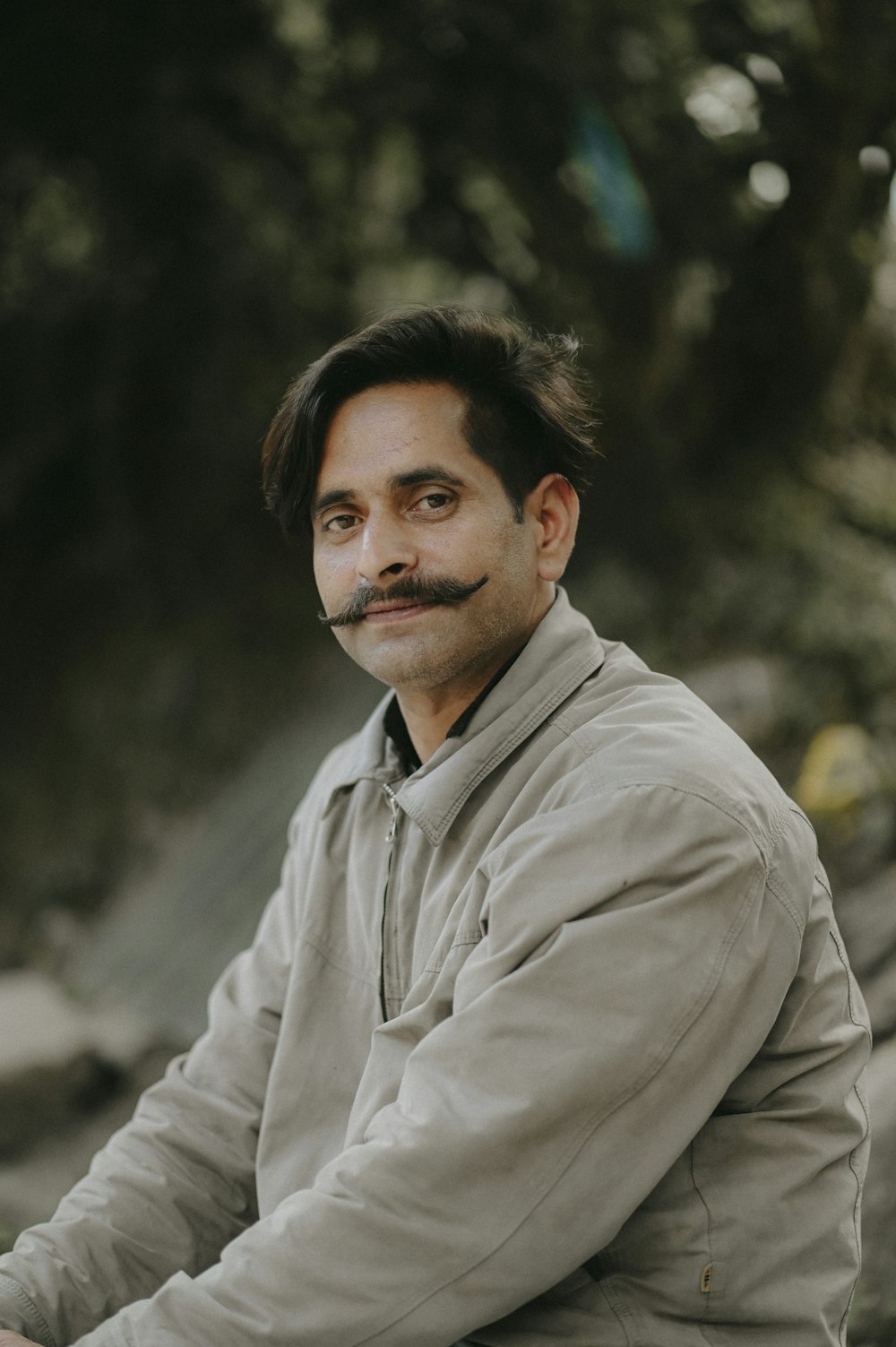 a man with a mustache sitting on a bench