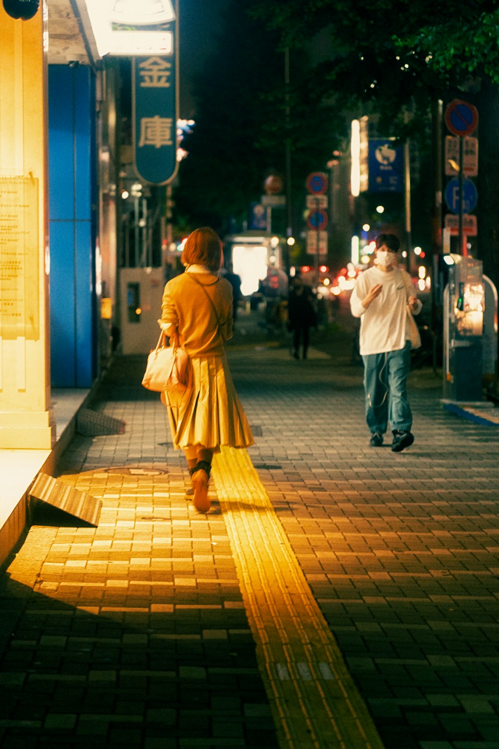 a woman walking down a street at night