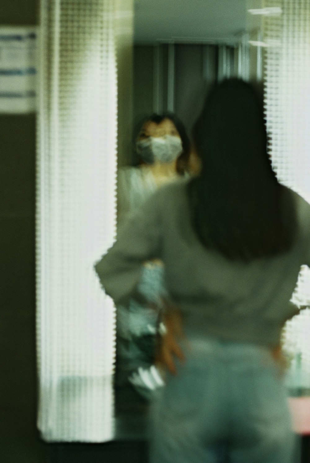 a blurry photo of a woman standing in front of a mirror