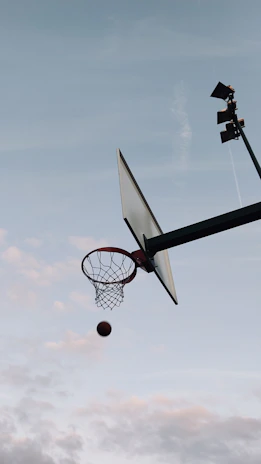 A dynamic shot of a basketball influencer filming a skill drill in a high school gym.