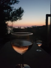 A serene seaside terrace with friends enjoying glasses of rosé at sunset.