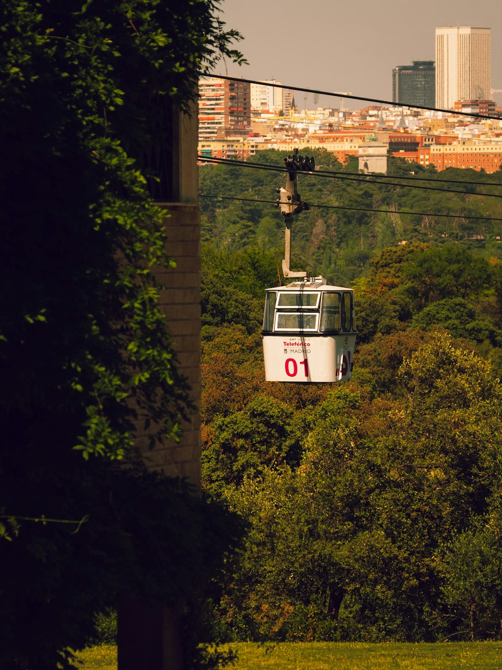 Eine Seilbahn, die einen Hügel hinauffährt, mit einer Stadt im Hintergrund