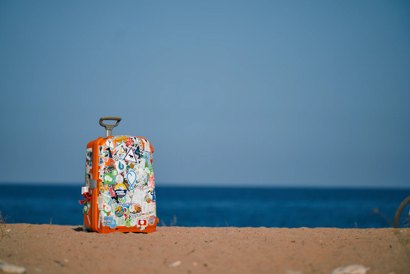 Reisekoffer am Strand als Beispiel für ein persönliches Rauchfrei-Sparziel