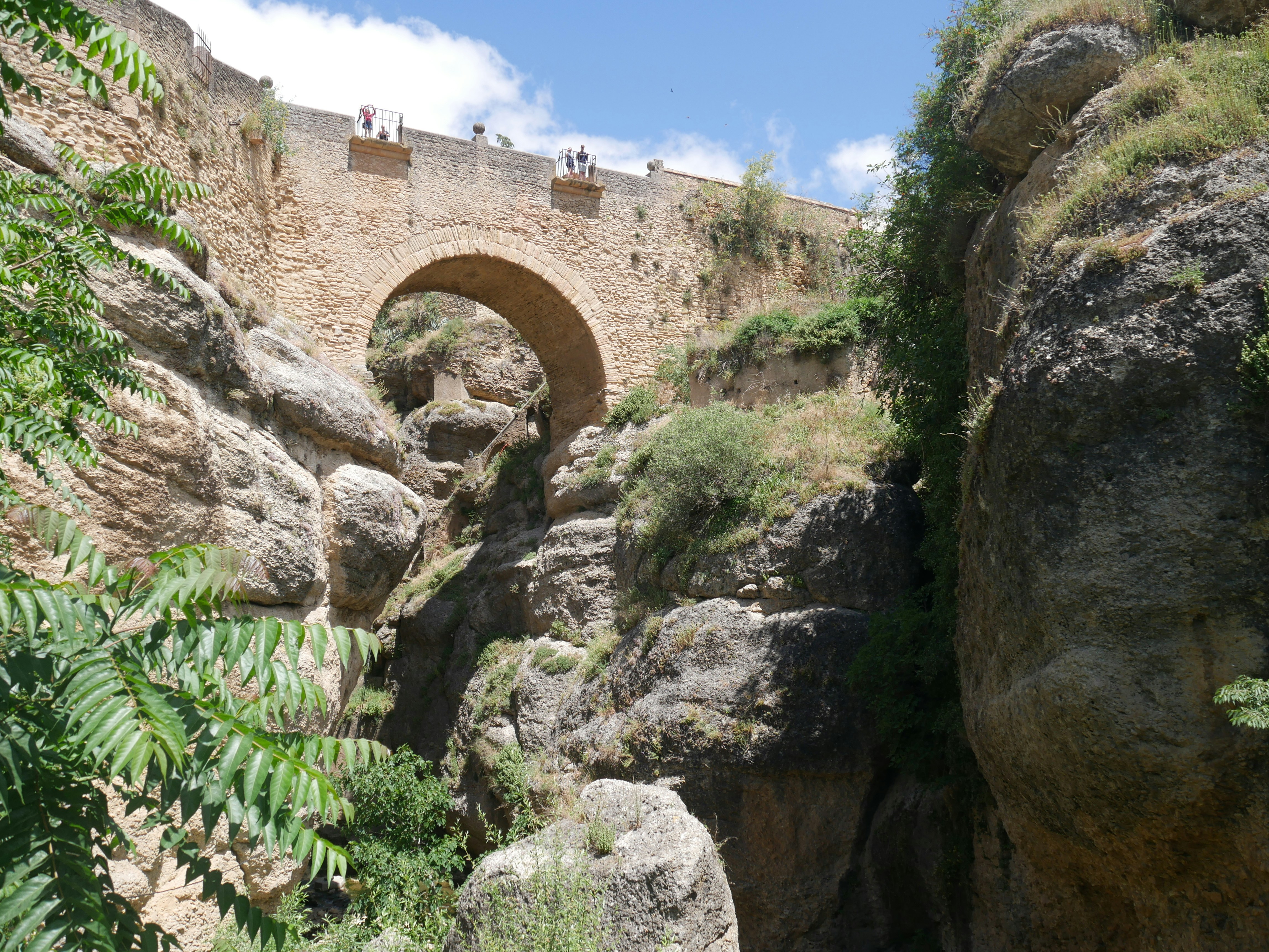a stone bridge over a river surrounded by rocks