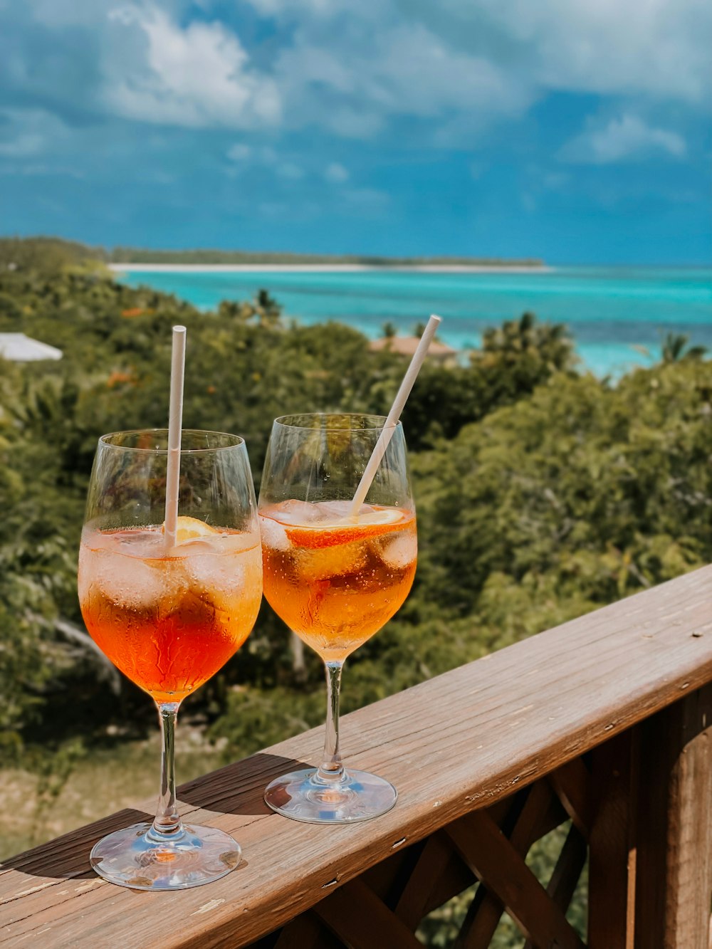 two glasses of wine are sitting on a deck