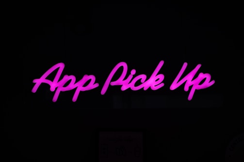 Neon pink text displaying 'App Pick Up' against a dark background.