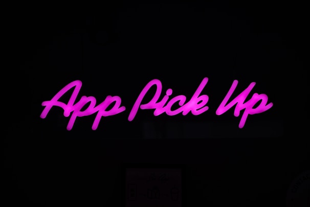 Neon pink text displaying 'App Pick Up' against a dark background.