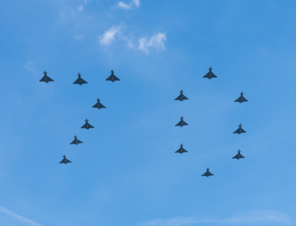 a formation of fighter jets flying through a blue sky