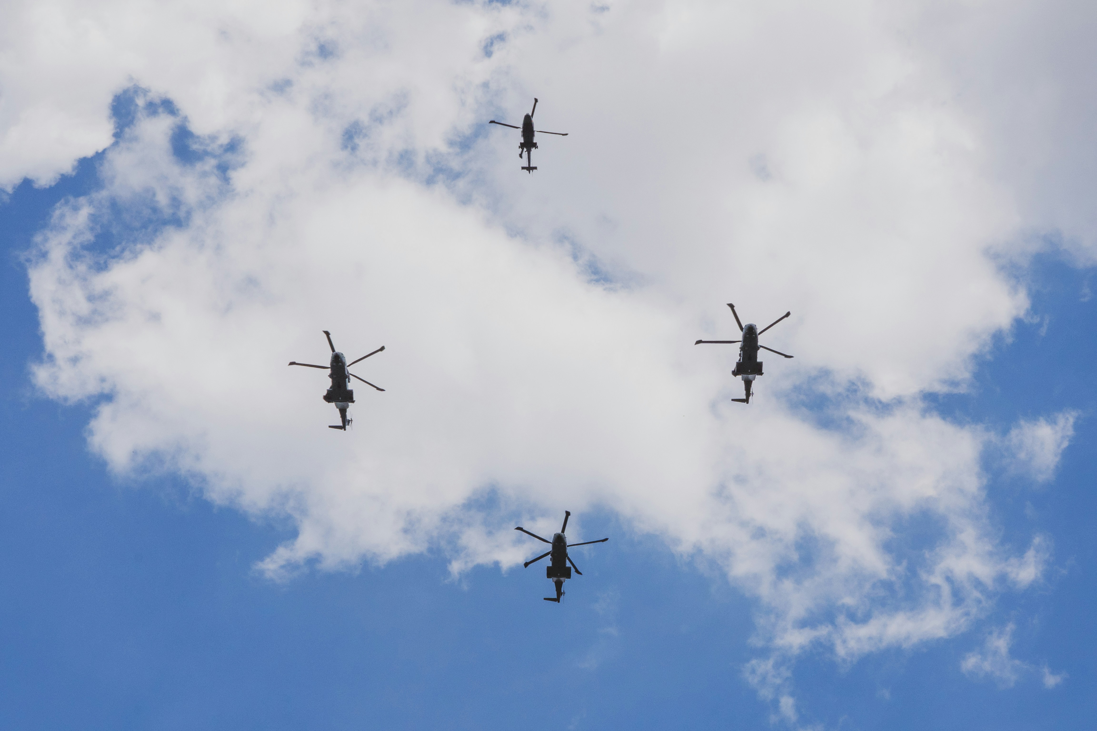 曇り空を飛ぶ軍用ヘリコプター群