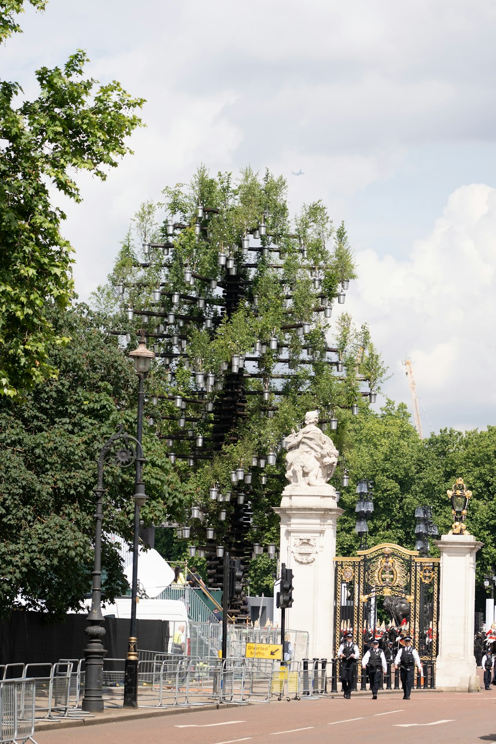 a group of people walking down a street next to a gate