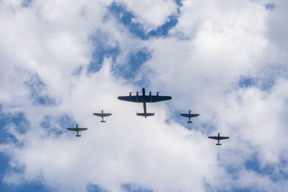 um grupo de aviões voando através de um céu nublado