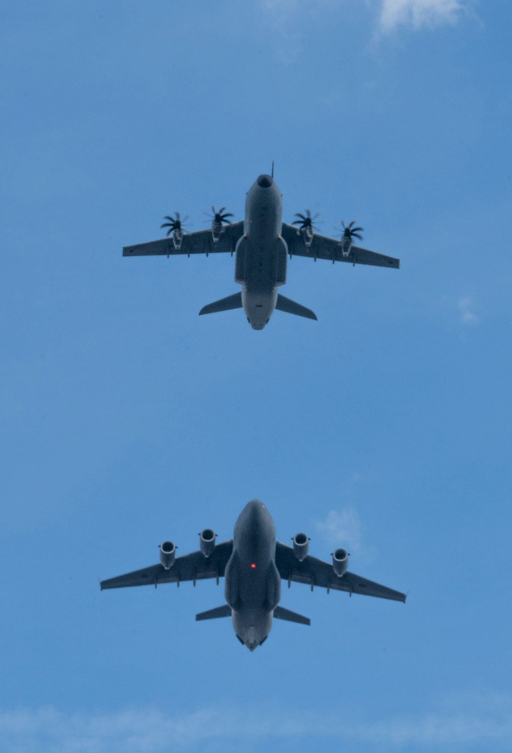 Due aerei che volano nell'aria con un cielo blu sullo sfondo