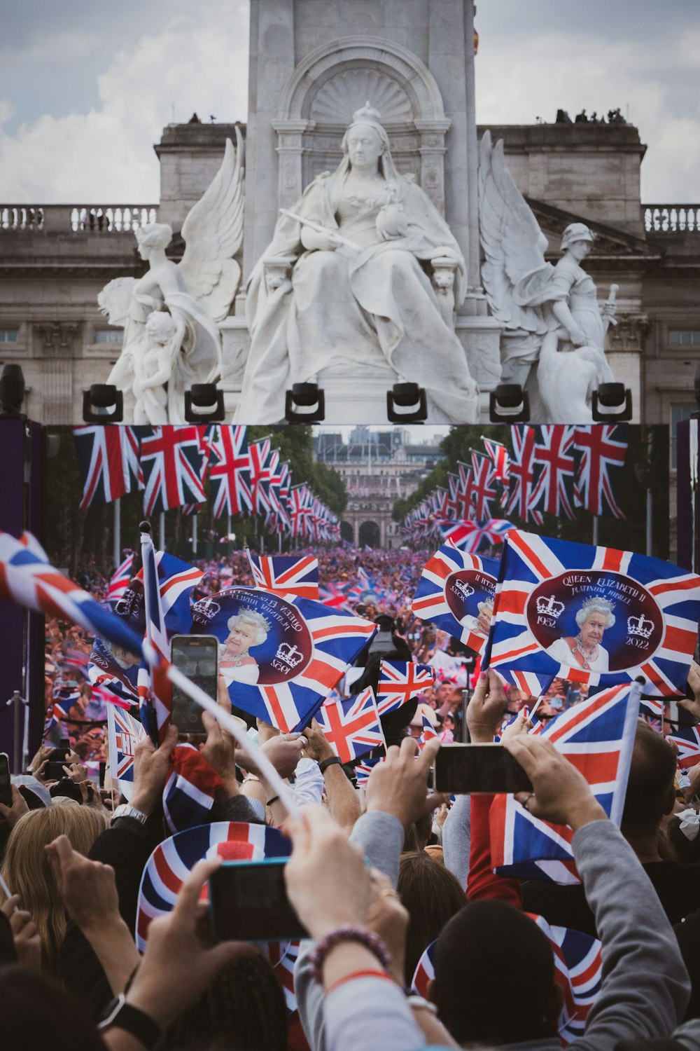 a crowd of people holding flags and taking pictures