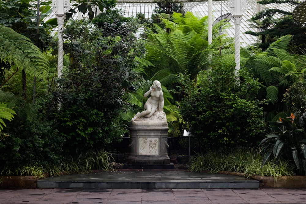 Eine Statue einer Frau umgeben von viel Grün
